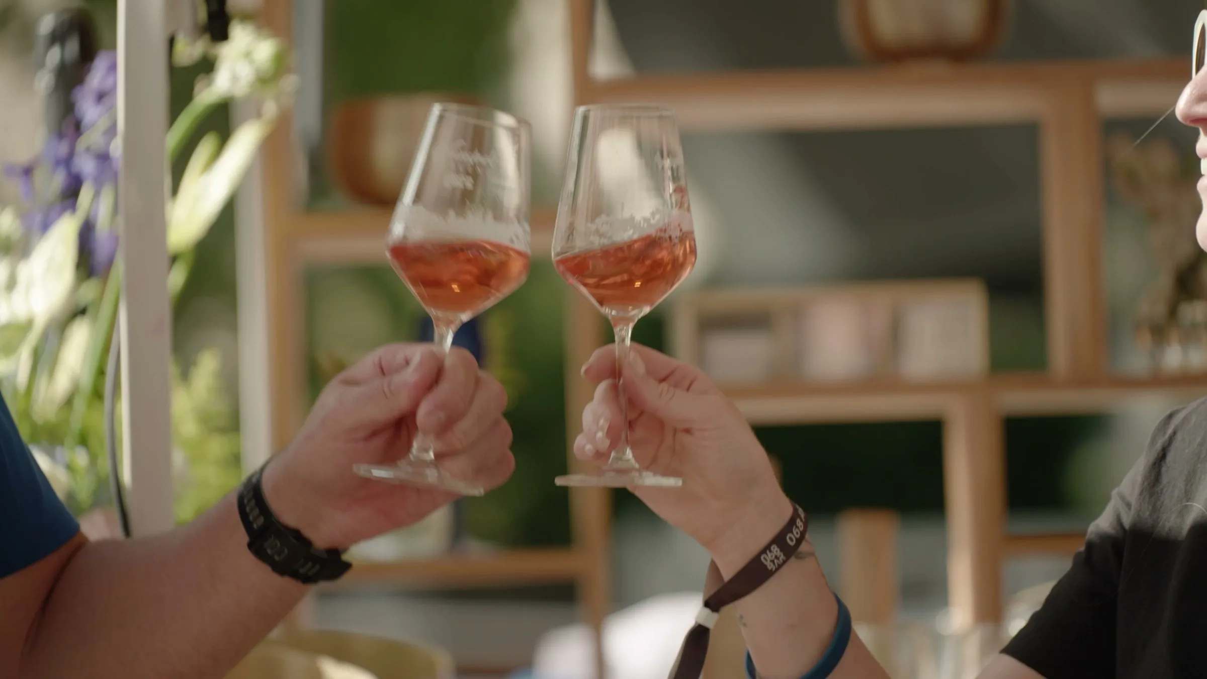 Zwei Gläser Rosé-Champagner werden angestoßen.