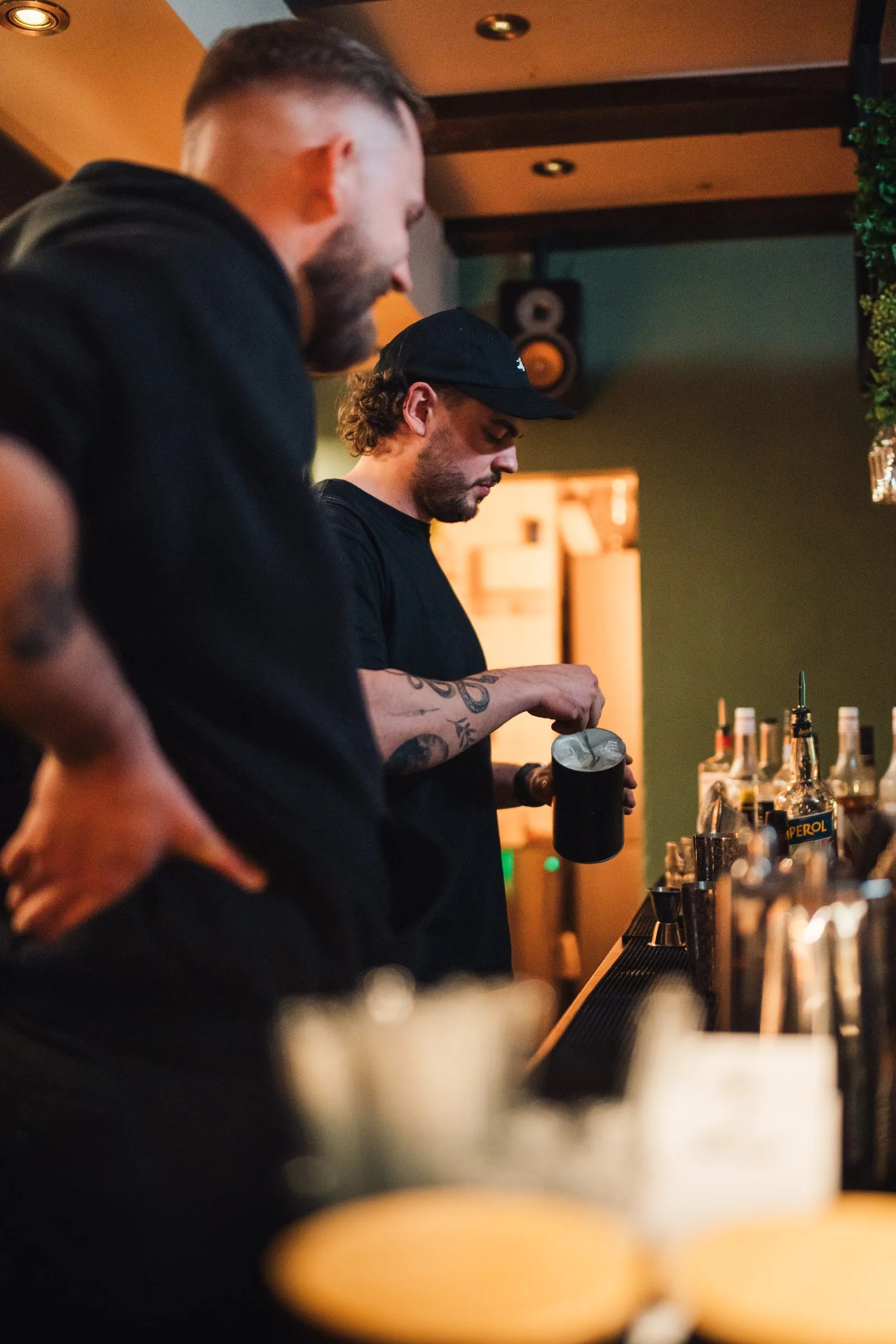 Zwei Barkeeper arbeiten hinter dem Tresen der 068 während einer Feier.