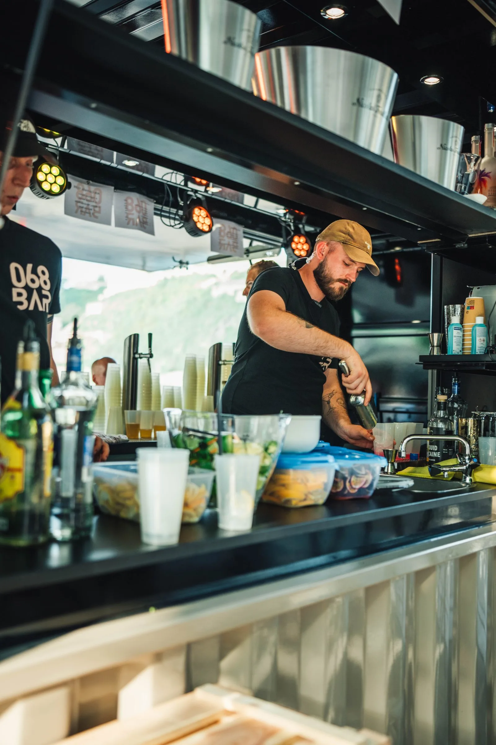Ein Barkeeper mixt Drinks in der mobilen 068-Containerbar.